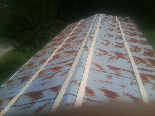 Rusted metal roof panels with new wood purlins before replacement — Storm Damage Roof Repair in Malaga by Roofing Brothers