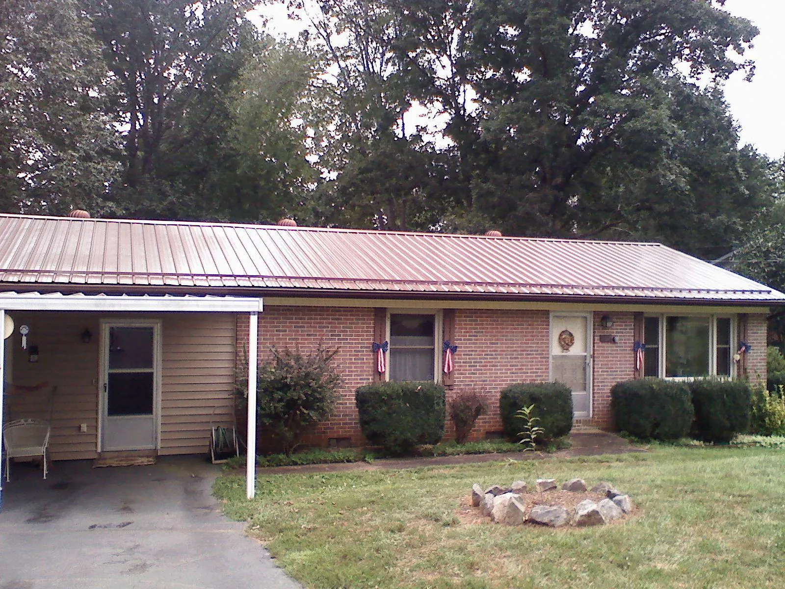 Bronze metal roof and carport on a brick ranch home — Roof Repair work by our crew in Malaga